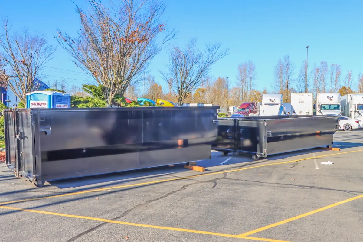 Professional dumpster rental service with roll-off container on residential driveway in Bedford